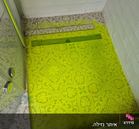 רצפת מקלחת עם אריחים מעוצבים ודלת זכוכית